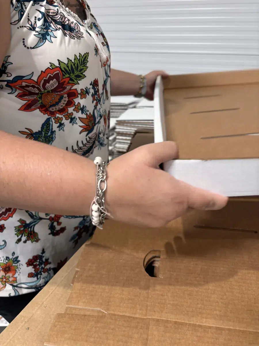 Main d'une femme qui façonne une étégère en carton