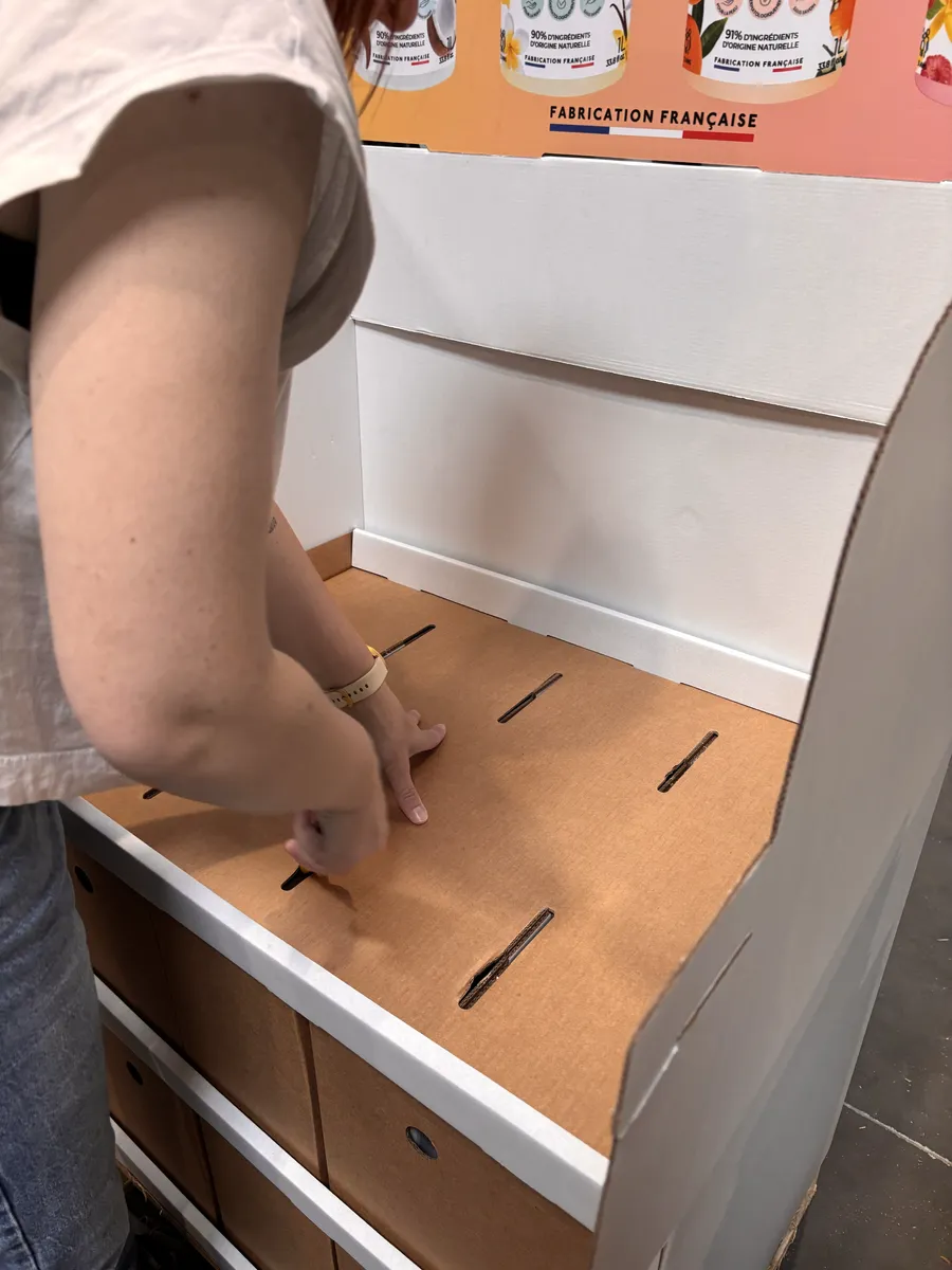 Mise en place étagère en carton dans stand de présentation